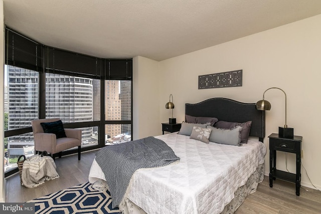 bedroom with hardwood / wood-style floors and a textured ceiling