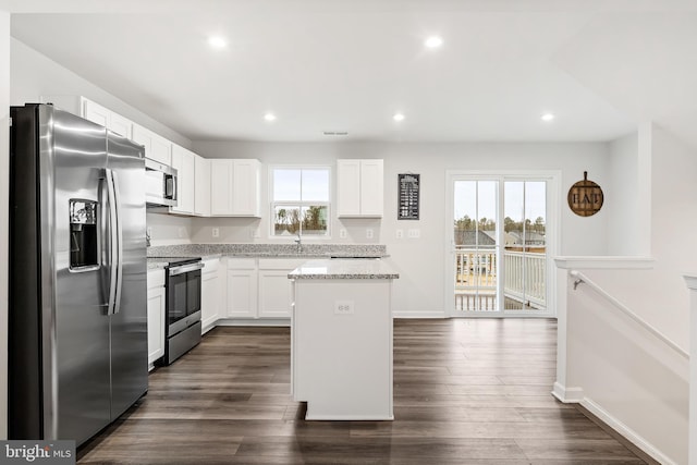 kitchen featuring white cabinets, a center island, stainless steel appliances, and a healthy amount of sunlight