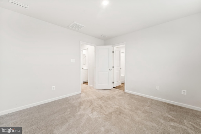 unfurnished room featuring light carpet