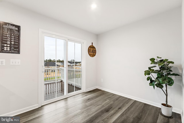 spare room featuring a wealth of natural light and dark hardwood / wood-style flooring