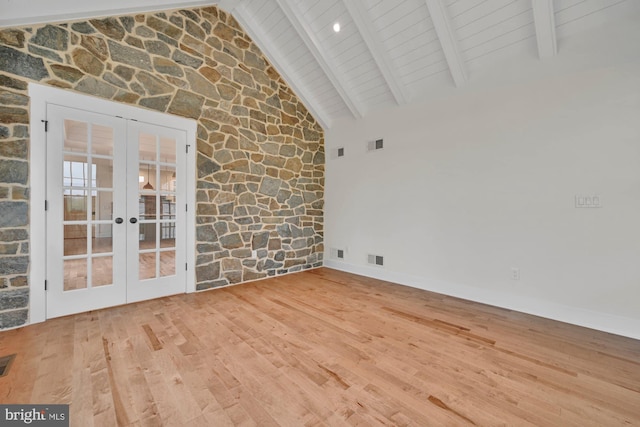 interior space with beam ceiling, french doors, high vaulted ceiling, and hardwood / wood-style floors