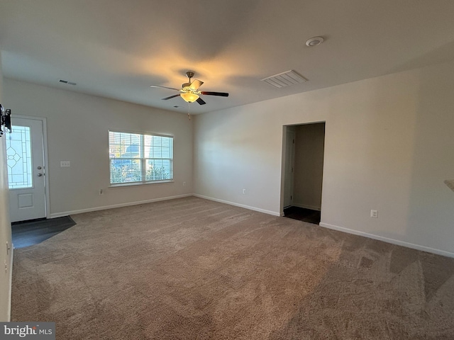 empty room featuring ceiling fan and carpet