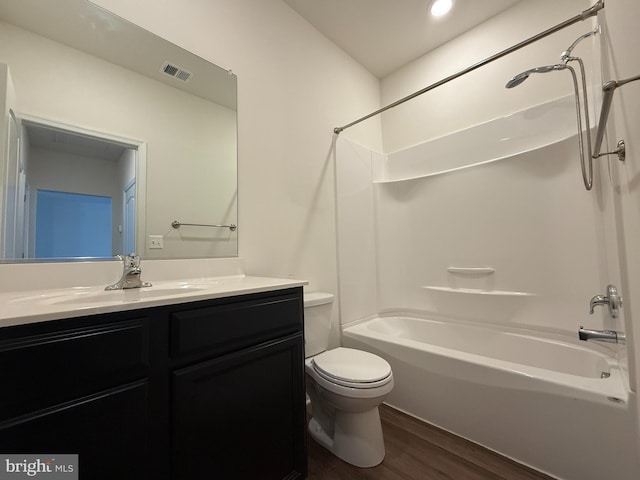 full bathroom with hardwood / wood-style flooring, vanity, toilet, and shower / washtub combination