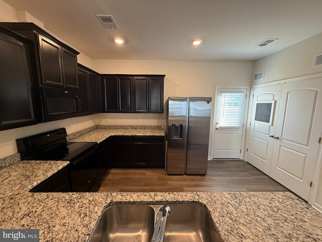 kitchen featuring light stone countertops, sink, black appliances, and dark hardwood / wood-style floors