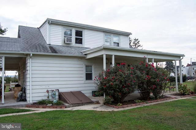 rear view of house featuring a yard and cooling unit