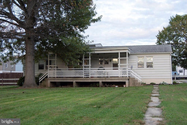 rear view of property featuring a lawn