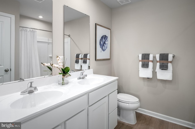 bathroom featuring a shower with curtain, vanity, wood-type flooring, and toilet