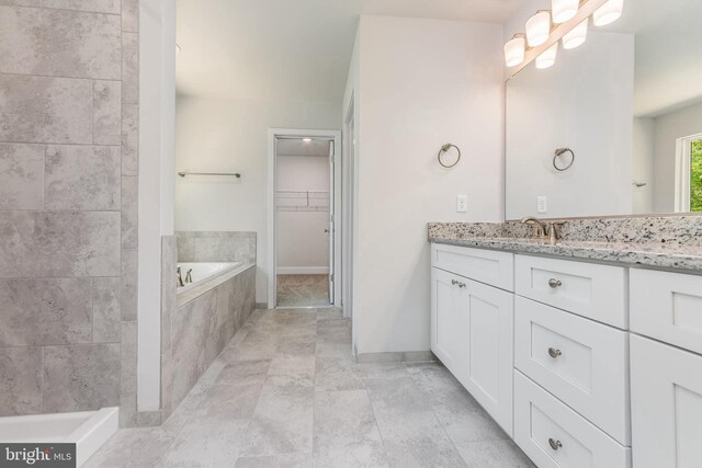 bathroom featuring vanity and tiled tub