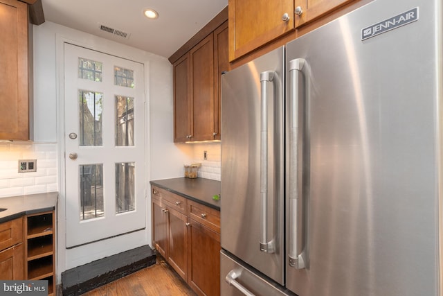 kitchen featuring high quality fridge, light wood-type flooring, and backsplash