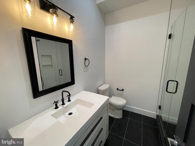 bathroom with tile patterned flooring, vanity, a shower with door, and toilet