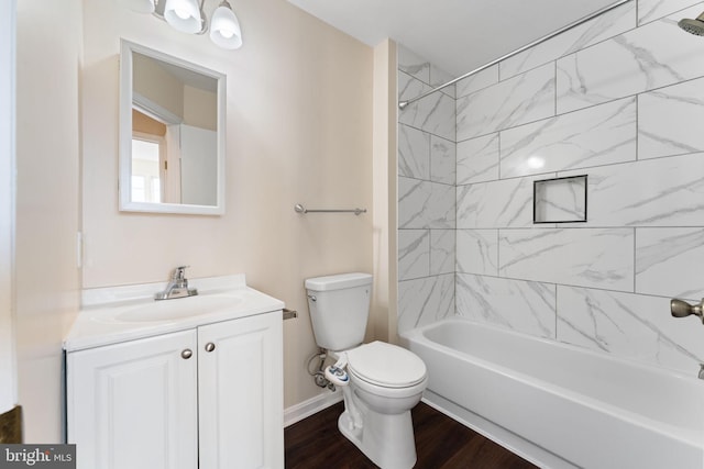 full bathroom with tiled shower / bath combo, vanity, hardwood / wood-style flooring, and toilet