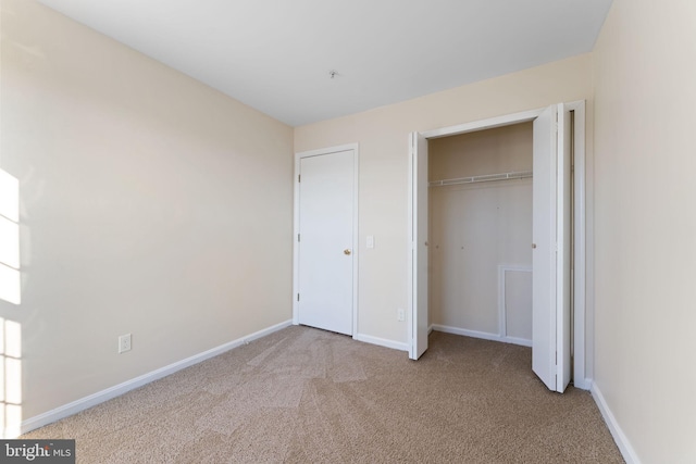 unfurnished bedroom featuring a closet and light carpet