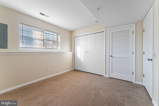 unfurnished bedroom featuring light carpet and electric panel