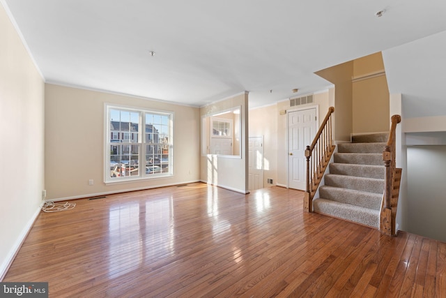 unfurnished living room with crown molding and hardwood / wood-style floors