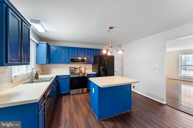 kitchen with sink, a kitchen island, stainless steel appliances, blue cabinets, and decorative light fixtures