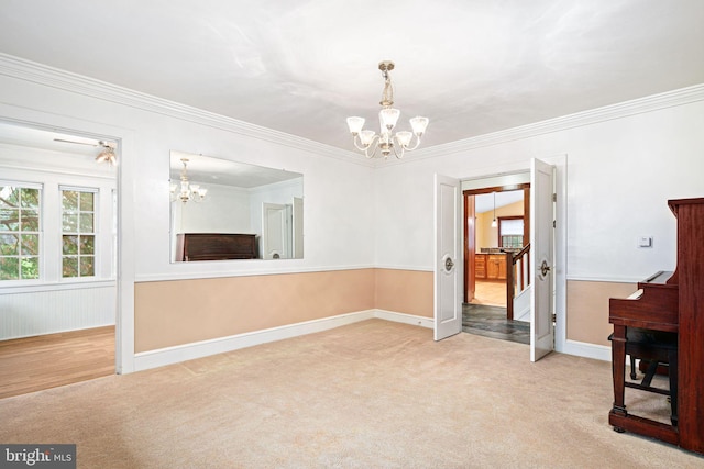 carpeted empty room with a notable chandelier and crown molding