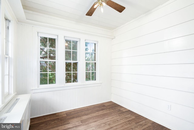 spare room with wooden walls, ceiling fan, and dark hardwood / wood-style floors