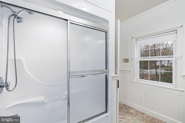 bathroom with wood walls, an enclosed shower, and ornamental molding