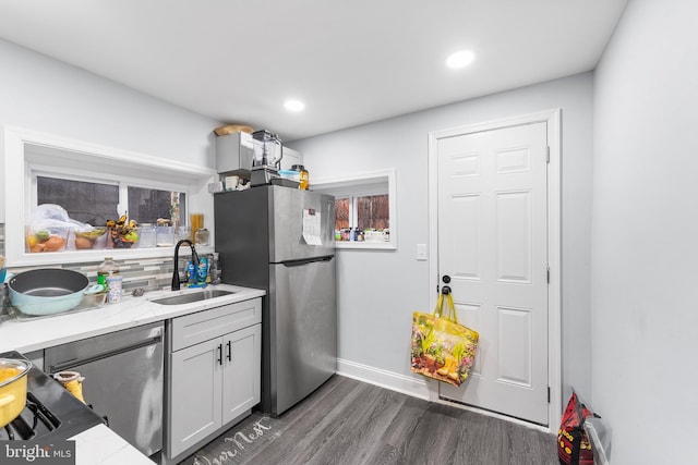 kitchen featuring gray cabinets, stainless steel refrigerator, dark wood-type flooring, sink, and backsplash