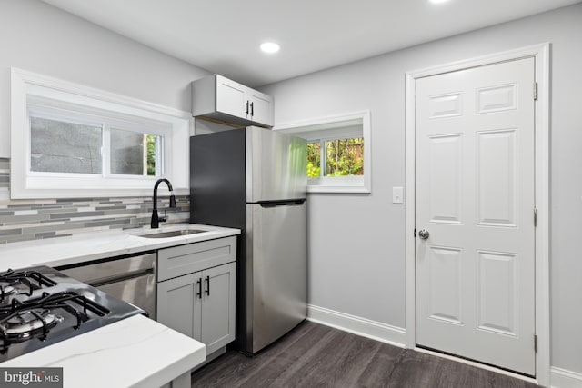 kitchen featuring sink, tasteful backsplash, stainless steel fridge, dark hardwood / wood-style flooring, and gray cabinetry