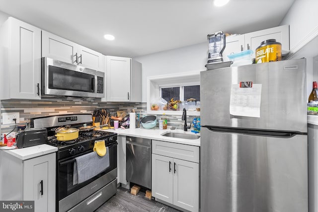 kitchen with white cabinets, appliances with stainless steel finishes, backsplash, and sink