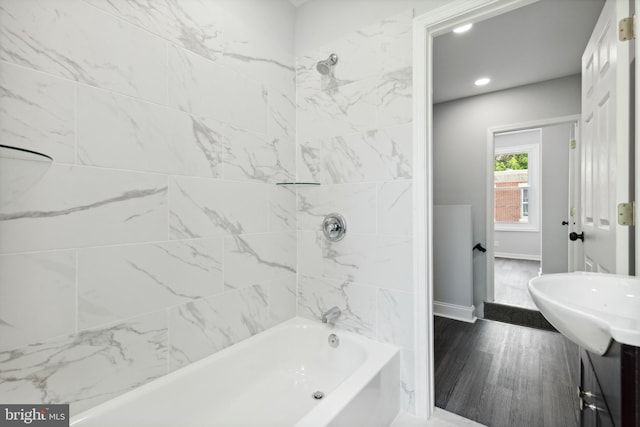 bathroom featuring tiled shower / bath combo and hardwood / wood-style flooring