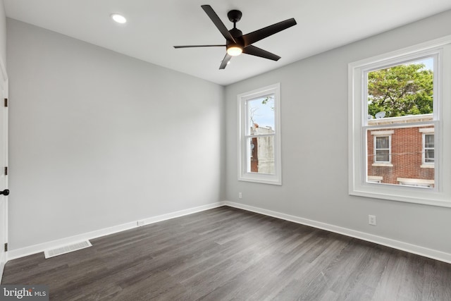 spare room with a healthy amount of sunlight, dark wood-type flooring, and ceiling fan