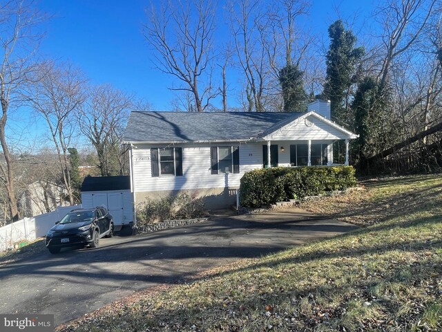 ranch-style home with covered porch and a shed