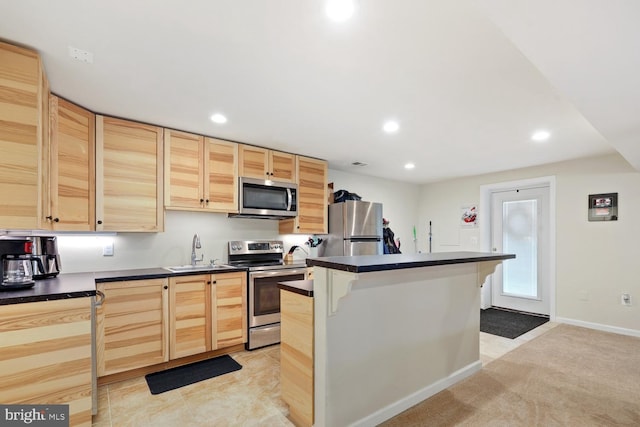 kitchen featuring a center island, sink, stainless steel appliances, and light brown cabinets