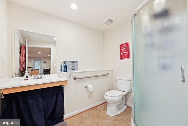 bathroom featuring tile patterned flooring, vanity, toilet, and a shower with shower door