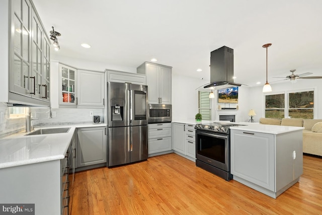 kitchen with gray cabinets, ceiling fan, island exhaust hood, and appliances with stainless steel finishes