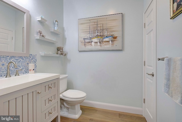 bathroom featuring wood-type flooring, vanity, and toilet