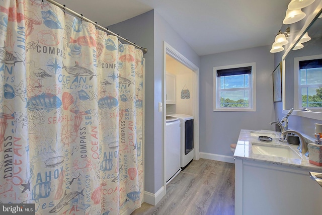 bathroom featuring hardwood / wood-style flooring, plenty of natural light, vanity, and washing machine and clothes dryer