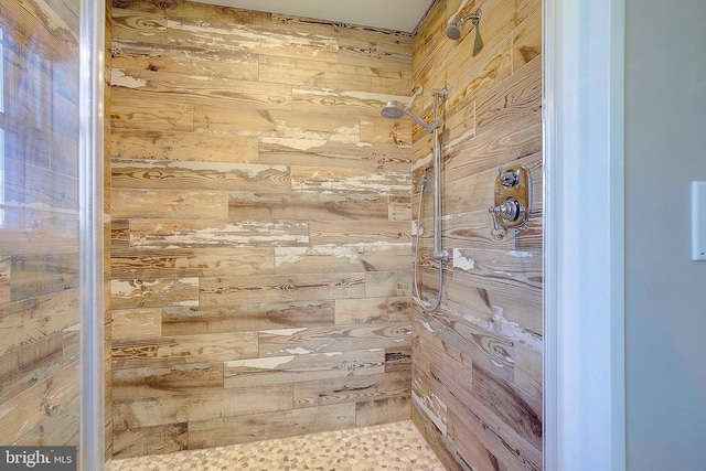 bathroom featuring wood walls and a shower