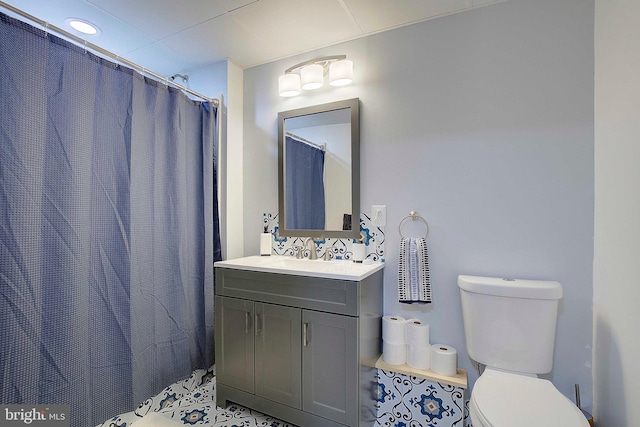 bathroom with toilet, a shower with curtain, vanity, and tile patterned floors