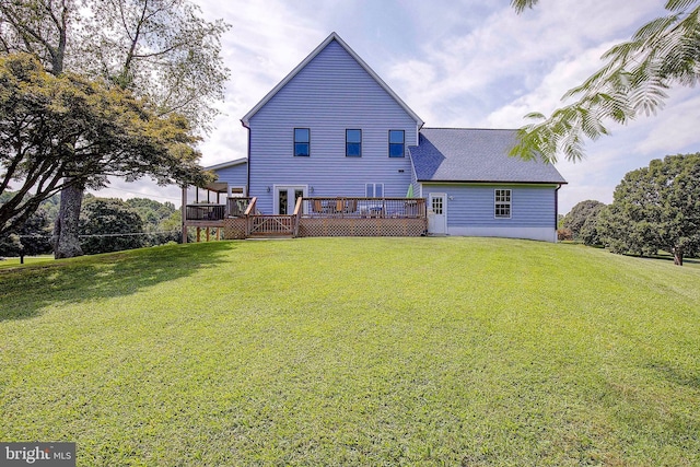 back of property with a lawn and a deck