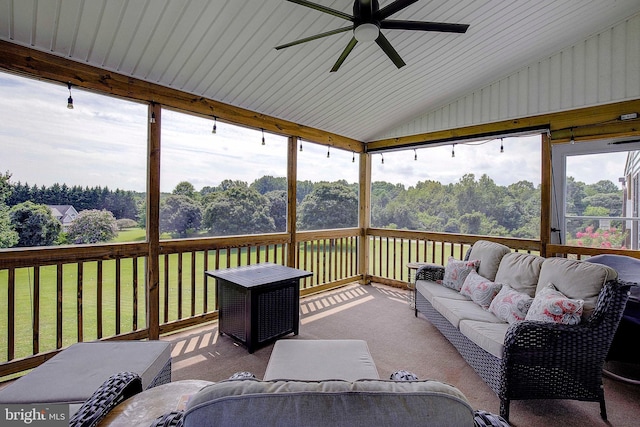 sunroom featuring ceiling fan, a healthy amount of sunlight, and vaulted ceiling