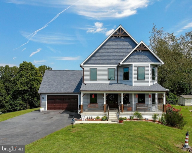 view of front of property with a front yard, a porch, and a garage