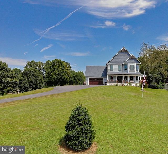 view of front of home with a garage, covered porch, and a front lawn