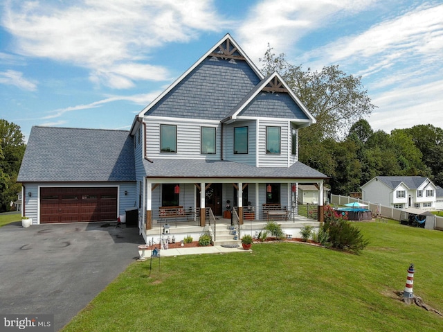 craftsman house featuring a garage, covered porch, and a front yard