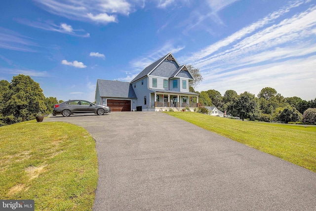 view of front of home with a porch, a garage, and a front lawn