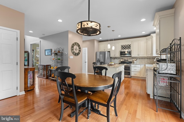 dining area featuring light wood-type flooring and sink