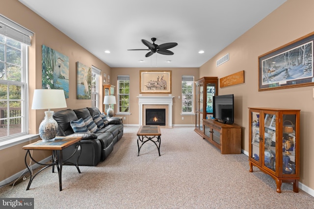 carpeted living room featuring ceiling fan and a wealth of natural light