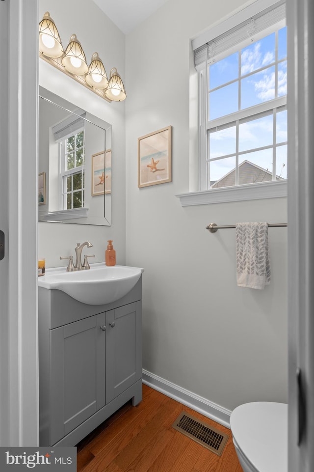 bathroom featuring vanity, wood-type flooring, and toilet