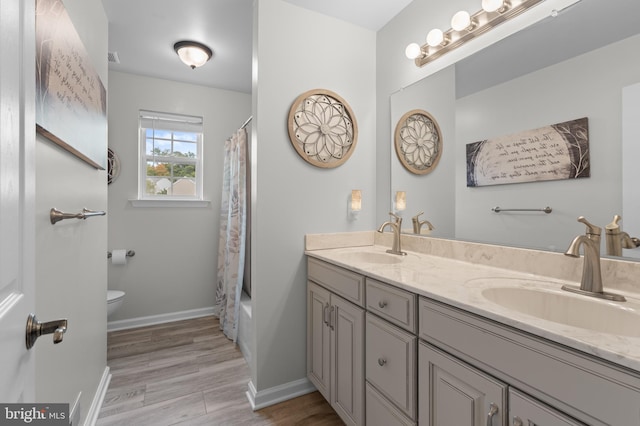 full bathroom with shower / bath combo, vanity, hardwood / wood-style flooring, and toilet