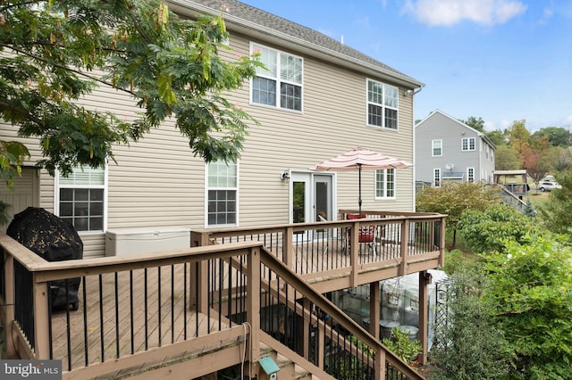 rear view of house featuring a wooden deck and french doors