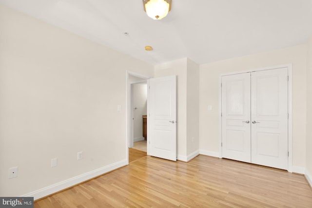 unfurnished bedroom featuring a closet and light wood-type flooring