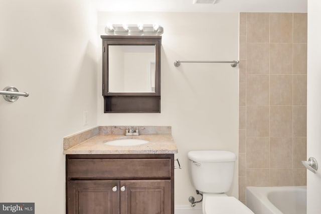 full bathroom featuring vanity, tiled shower / bath combo, and toilet