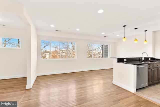 kitchen with decorative light fixtures, a healthy amount of sunlight, sink, and light hardwood / wood-style flooring