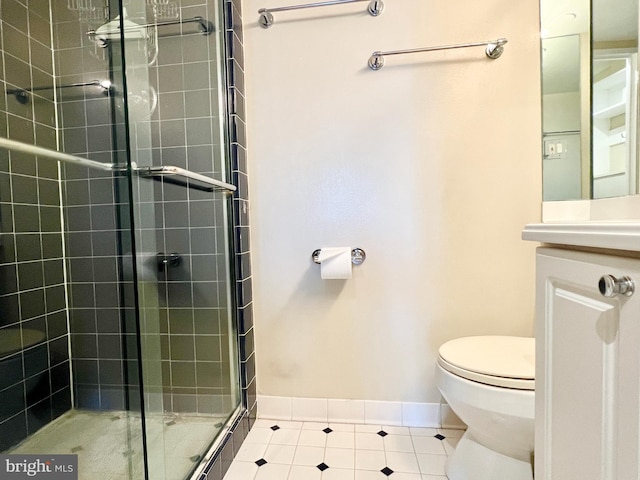 bathroom featuring tile patterned floors, toilet, an enclosed shower, and vanity